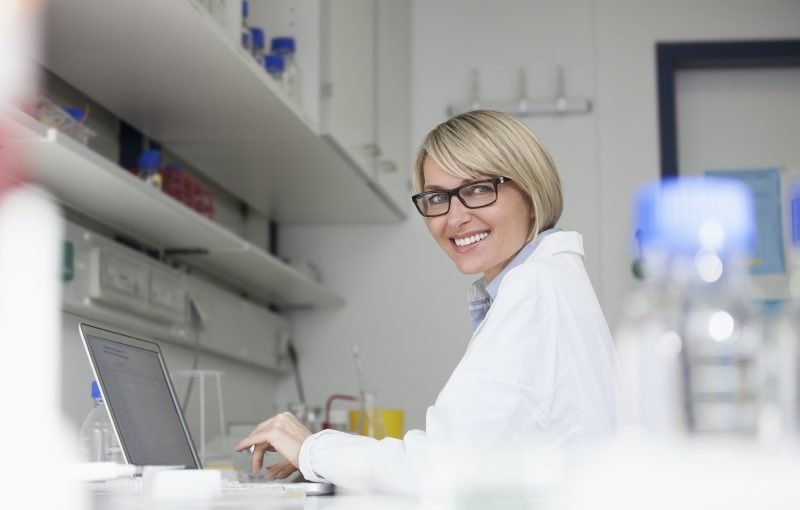 smiling-scientist-using-laptop-in-laboratory.jpg